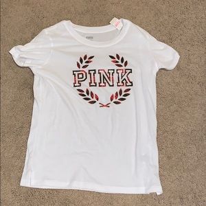 White pink shirt with red leaf kind of logo